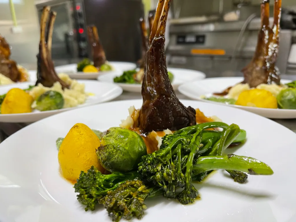 Rack of lamb plated with seasonal vegetables in the Club Boutique Hotel kitchen, Cunnamulla