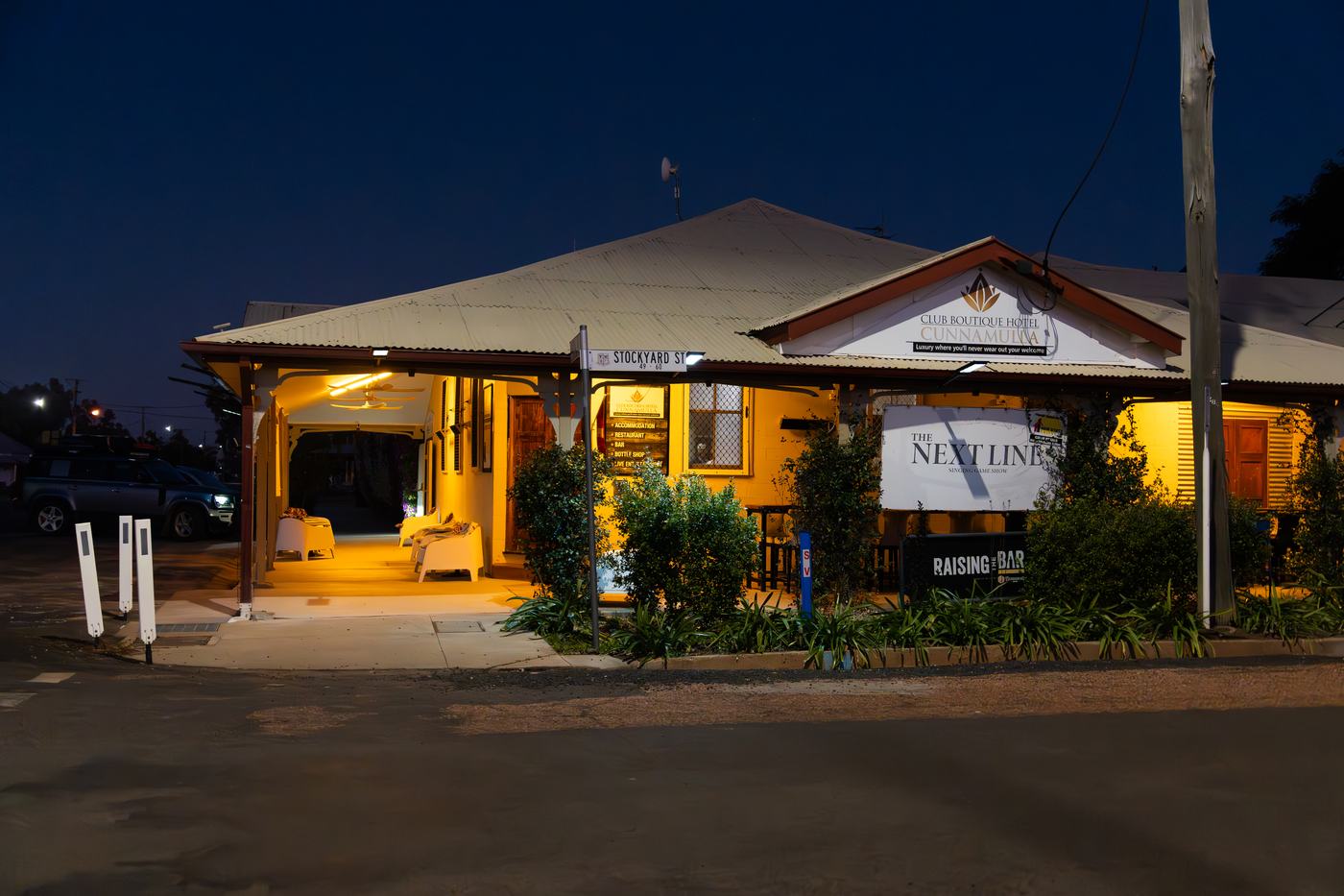 Club Boutique Hotel Cunnamulla frontage lit warmly at dusk under a deep blue sky.